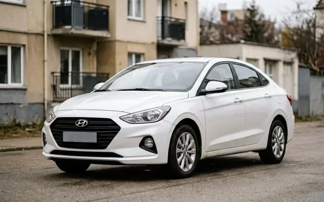 Белый Hyundai Solaris седан на парковке у торгового центра в солнечный день