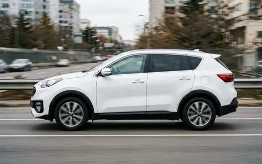 Белый Kia Sportage в профиль на фоне заправки под Тверью