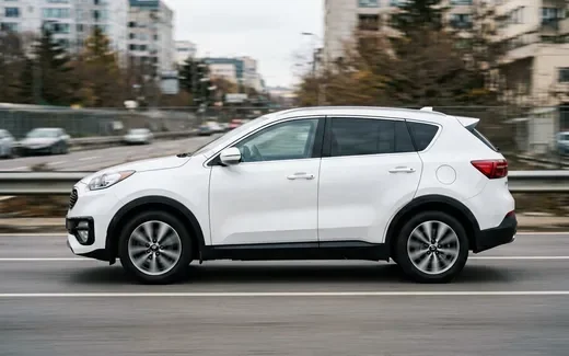 Белый Kia Sportage в профиль на фоне заправки под Тверью